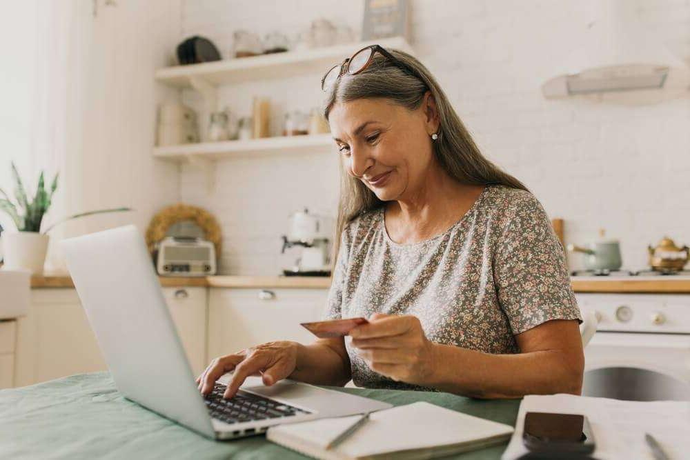 Woman on laptop with bank card